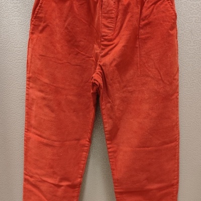 Calças vermelhas com cós elástico penduradas numa cabide preta