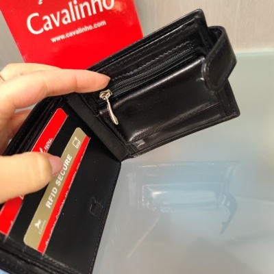 Carteira preta de couro aberta com cartão RFID e embalagem vermelha Cavalinho ao fundo