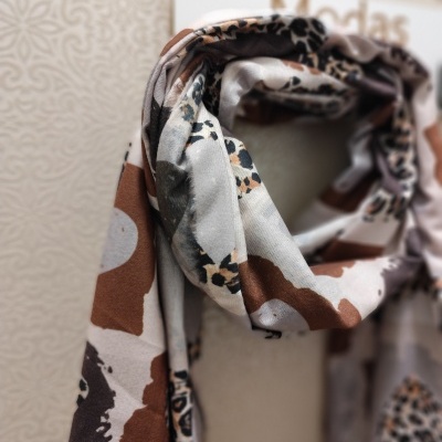 Lenço com padrão animal print em tons de castanho e bege pendurado