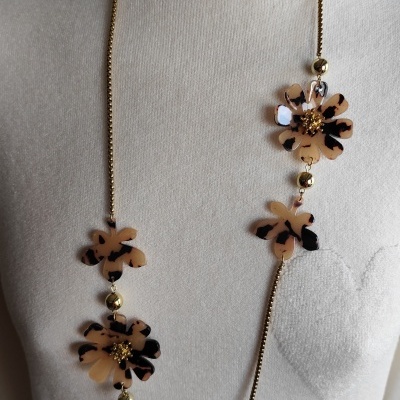 Colar comprido com flores bege e preto em manequim com camisola branca