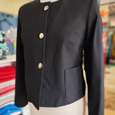 Casaco preto com botões prateados numa loja de roupa