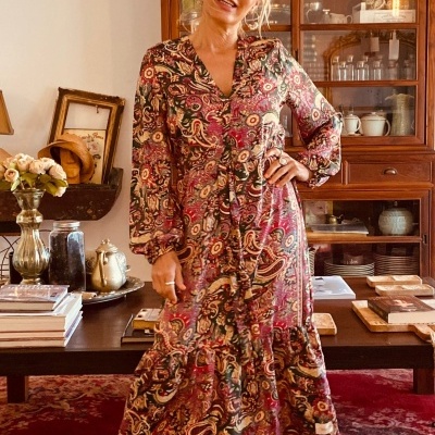 Vestido comprido com padrão floral e paisley usado por mulher em sala de estar