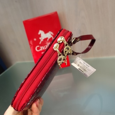 Carteira vermelha com fechos dourados e pendentes em forma de ferradura