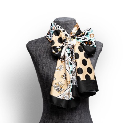 Lenço colorido com padrões variados mostrado em busto cinzento