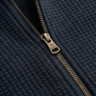 Fecho éclair metálico dourado em tecido azul escuro texturizado