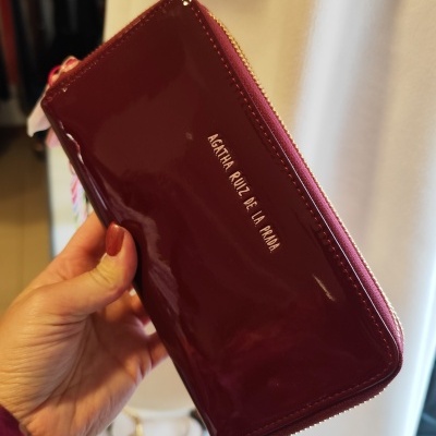 Carteira bordeaux em verniz com fecho dourado e texto Agatha Ruiz de la Prada