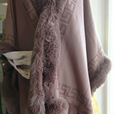 Capa castanha com pêlo sintético e padrão geométrico em manequim