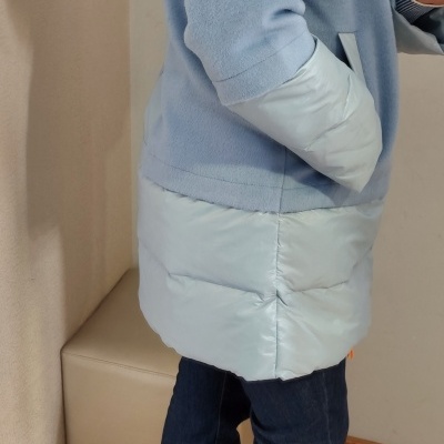 Pessoa com casaco azul claro e calças de ganga escuras