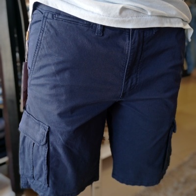 Calções cargo azuis escuros com bolsos laterais numa manequim