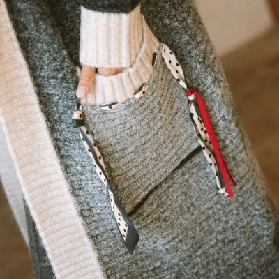 Roupa de malha cinzenta com bolso e detalhes em fita de seda