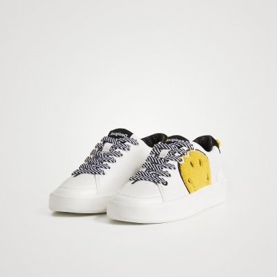 Ténis brancos com coração amarelo nas laterais e atacadores preto e branco
