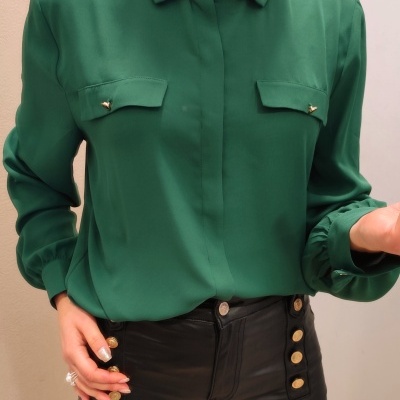 Blusa verde com bolsos e calças pretas com botões dourados