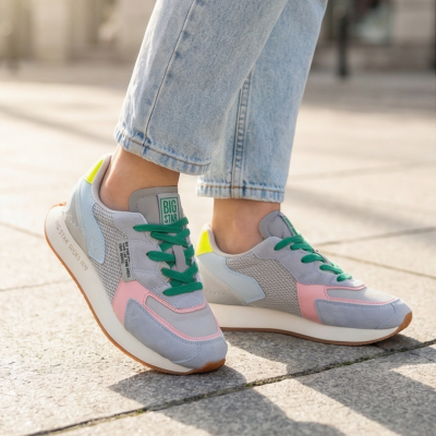 Sapatilhas BIG STAR multicoloridas com jeans junto a solo exterior de pedra