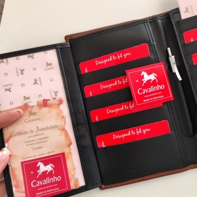 Carteira preta de couro com cartões vermelhos e etiqueta Cavalinho