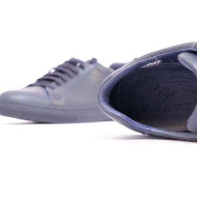 Par de sapatilhas azul-escuro com atacadores em fundo branco