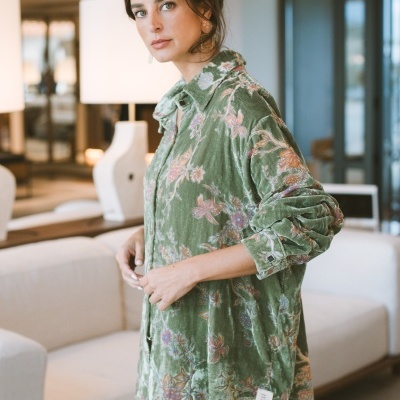 Camisa verde aveludada com padrão floral usada por mulher em ambiente interior