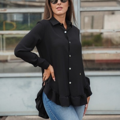 Blusa preta com botões brancos e folhos, usada com jeans azul