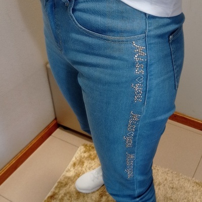 Calças de ganga azul médio com strass e t-shirt branca numa pessoa