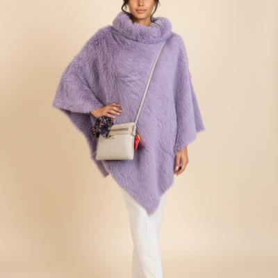 Mulher de capa roxa felpuda e mala bege com lenço