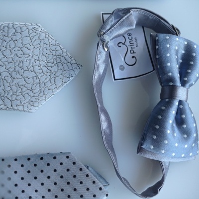 Gravata borboleta azul claro com bolinhas brancas e dois lenços de bolso cinza com diferentes padrões