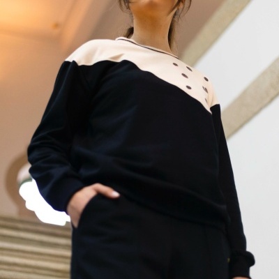 Mulher com sweatshirt preta e creme em escadaria interior