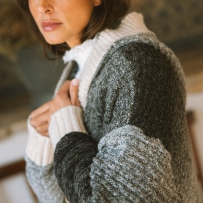 Mulher com cardigan de malha cinza e branca, textura felpuda, gola alta e punhos brancos