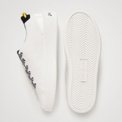 Sapatilhas brancas com atacadores pretos em espiral e sola branca com texto 'bershka'