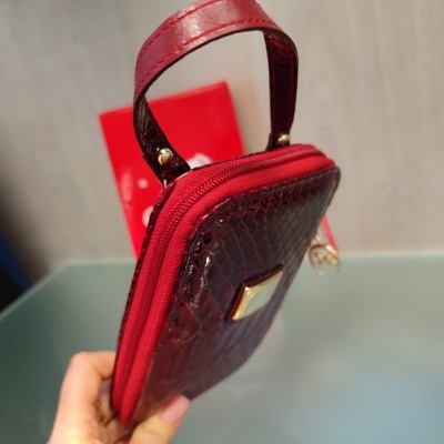 Carteira pequena vermelha com padrão texturizado, fecho de correr e pega vermelha