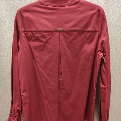 Camisa vermelha de manga comprida pendurada num cabide preto