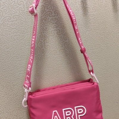Mala cor-de-rosa com alça e letras ARP bordadas