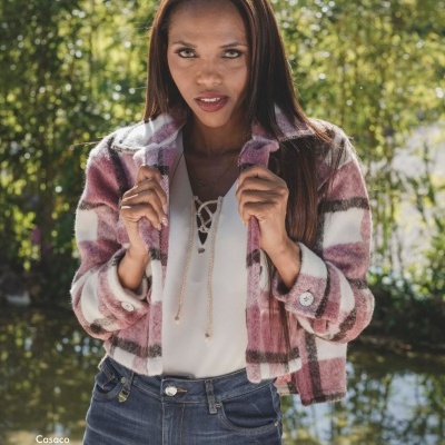 Mulher com casaco xadrez rosa e branco ao ar livre