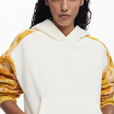 Sweatshirt creme com mangas xadrez amarelo e branco, capuz e bolso canguru em fundo branco