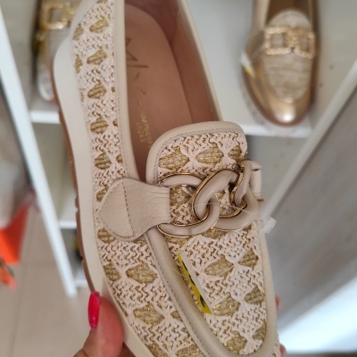 Sapato feminino com padrão branco e dourado e corrente decorativa