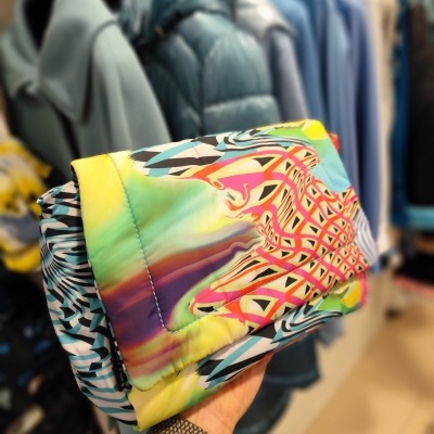 Casaco acolchoado colorido com padrão abstrato em tons de amarelo, verde, rosa, azul e preto