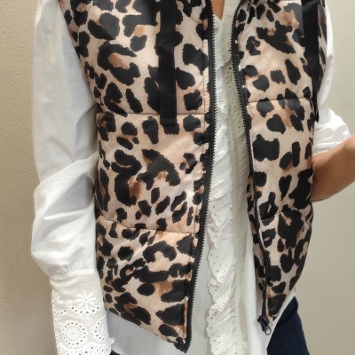 Colete acolchoado com estampa animal, camisa branca com renda e calças escuras