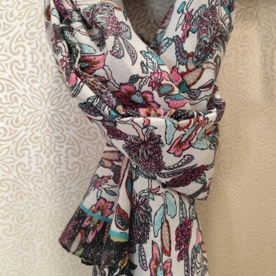 Lenço floral colorido pendurado num cabide com a palavra Modas