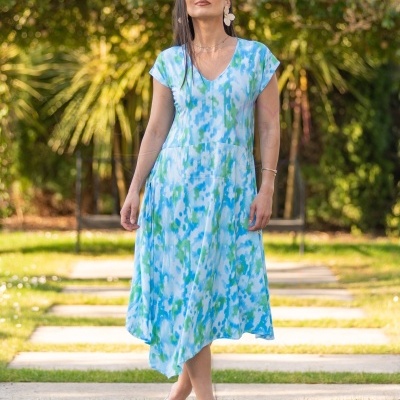 Vestido fluido azul, verde e branco com padrão abstrato e decote em V