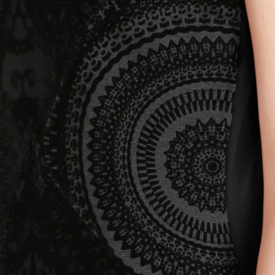 Vestido preto com padrão circular em veludo preto e cinzento e braço da pessoa que o usa