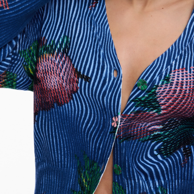 Casaco de malha azul com padrão de listras e flores coloridas com botões coloridos