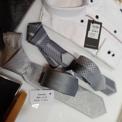 Três gravatas cinzentas com vários padrões, camisa branca e etiquetas de preços
