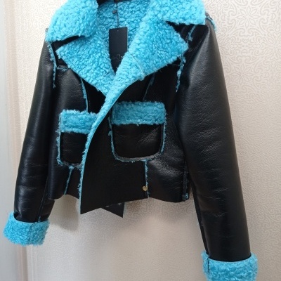 Casaco preto com detalhes em pelúcia azul claro pendurado num cabide