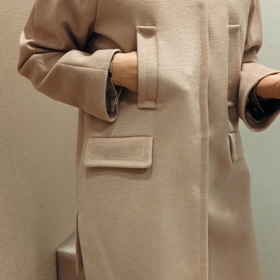 Casaco bege em tecido grosso com bolsos e gola larga