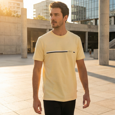 Homem com t-shirt amarela casual e risca preta, em ambiente urbano moderno