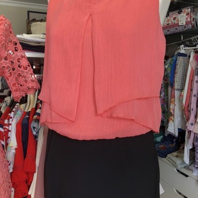 Top feminino cor de coral sem mangas em manequim