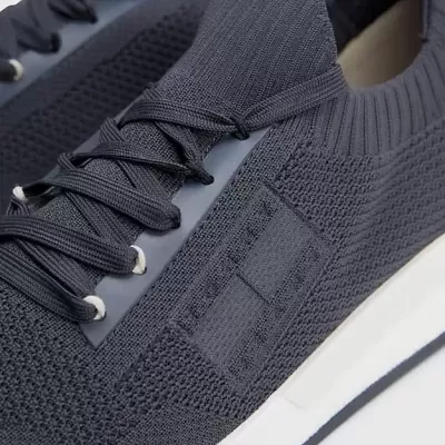 Ténis desportivos azuis em tecido malha com sola branca.