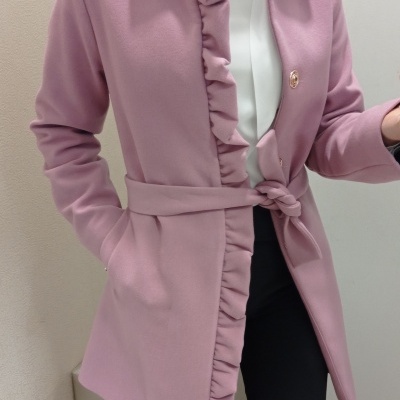 Casaco feminino rosa com folhos e cinto usado por mulher