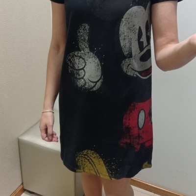 Vestido curto preto com estampa do Mickey Mouse em ambiente interior