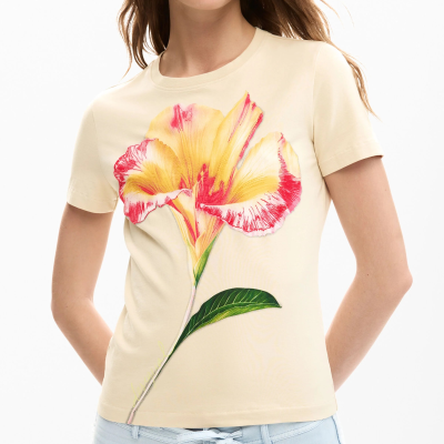T-shirt bege com estampa de flor e calças claras com bolso e laço