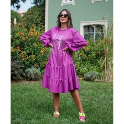 Mulher com vestido roxo bufante em relvado de jardim