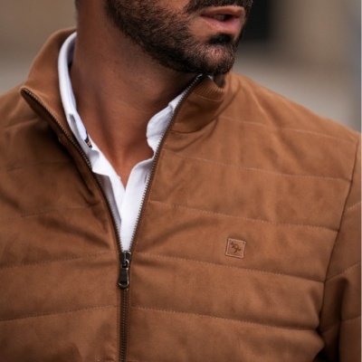 Homem a usar casaco acolchoado castanho com fecho de correr e óculos escuros